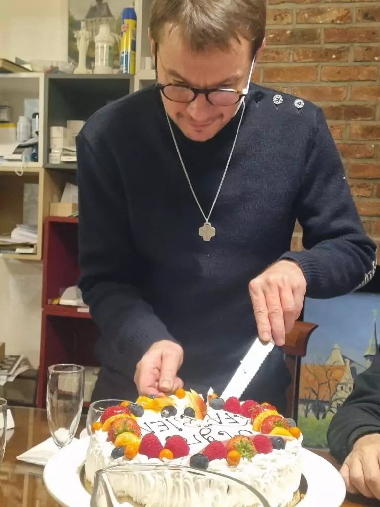  Le père Fabien coupe le gâteau d'anniversaire à la Communauté.